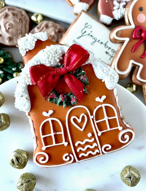 Pierniczek lukrowany piernikowa chatka z czerwoną kokardą Pierniczek lukrowany piernikowa chatka z czerwoną kokardą